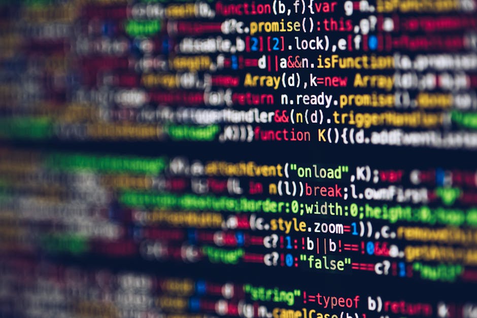Close-up photograph of a computer screen displaying a dense code editor with multicolored syntax highlighting. The code includes various programming keywords, variables, functions, and symbols in shad